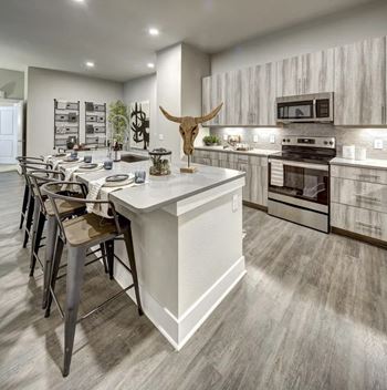 A modern kitchen with a white island and a cow skull as a decoration.